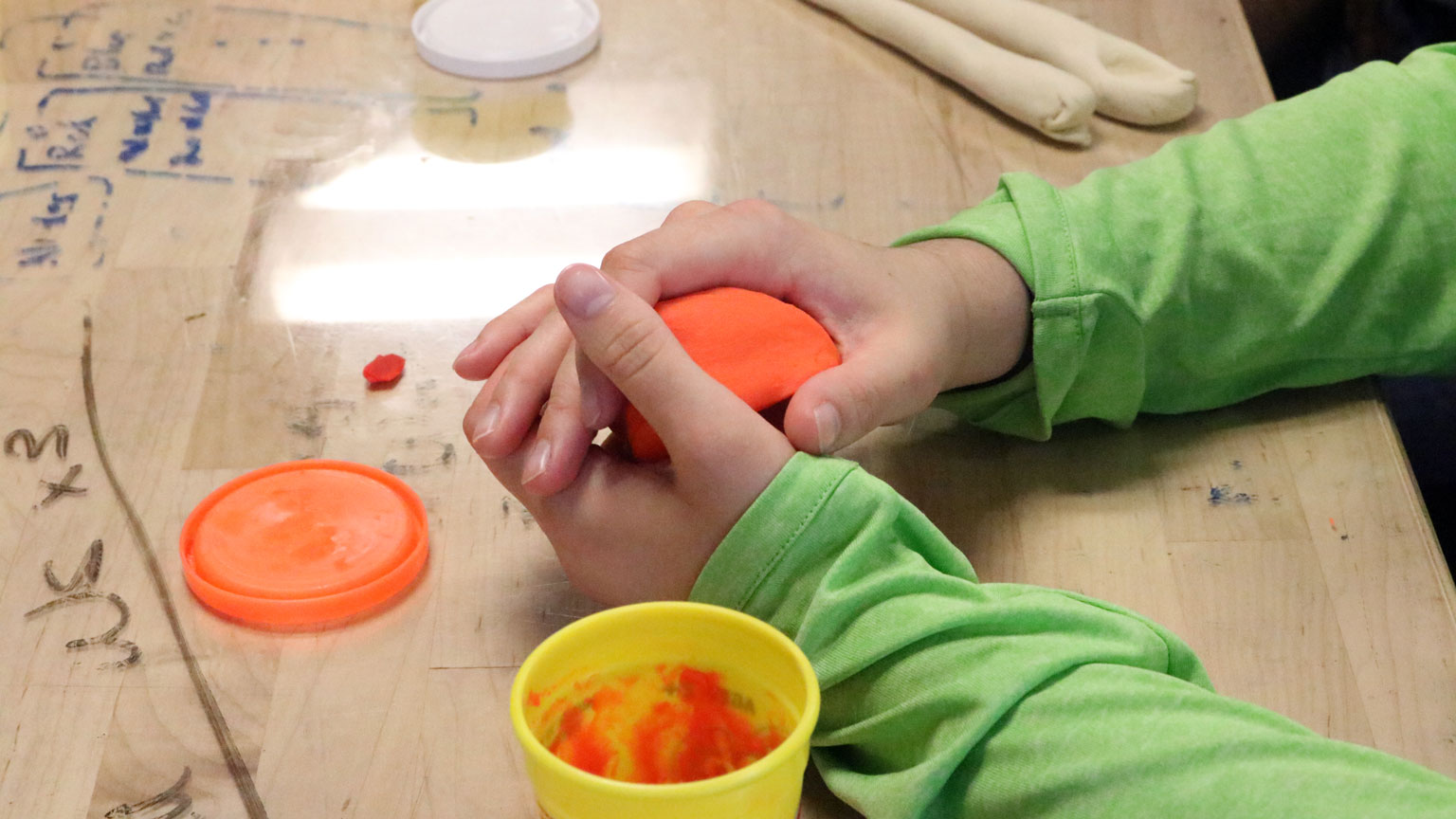 Hands mold dough into prototype utensil during a Design Bloc workshop on empathy for the user. 